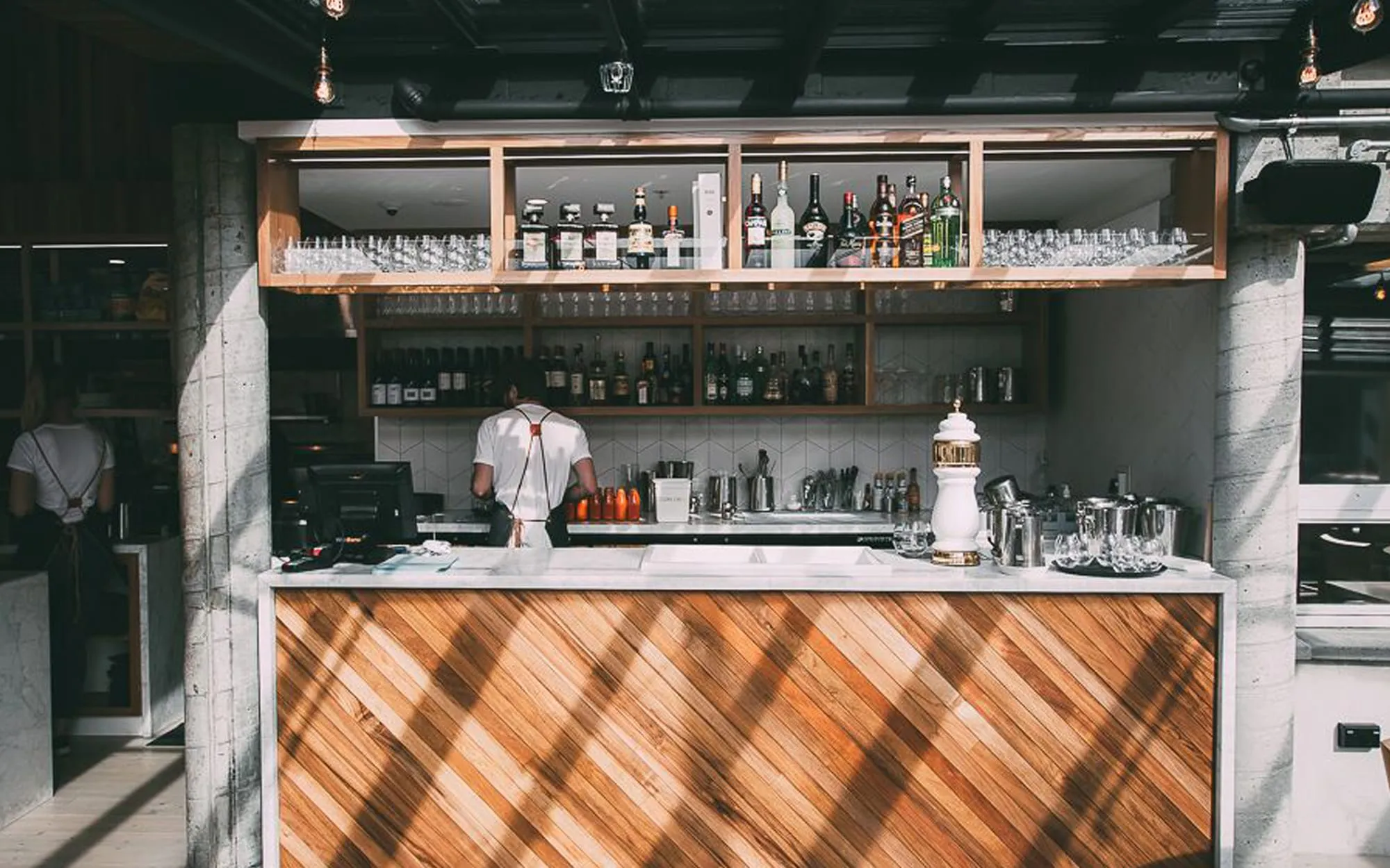 The bar counter with its timber front and shelves of bottles