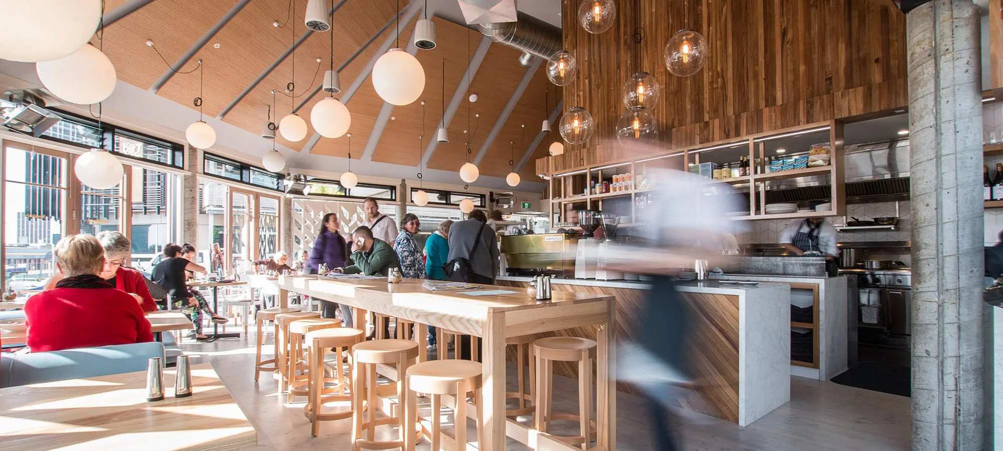 The dining room: long timber tables under hanging pendant lights