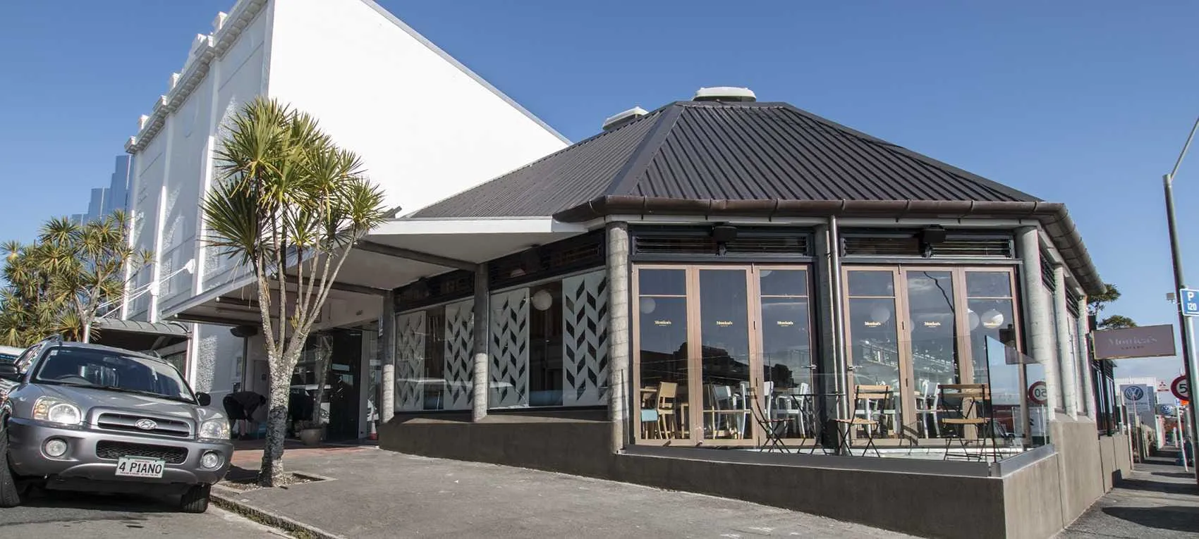 Monica’s Eatery from the street: a glass pavilion with the name on its windows