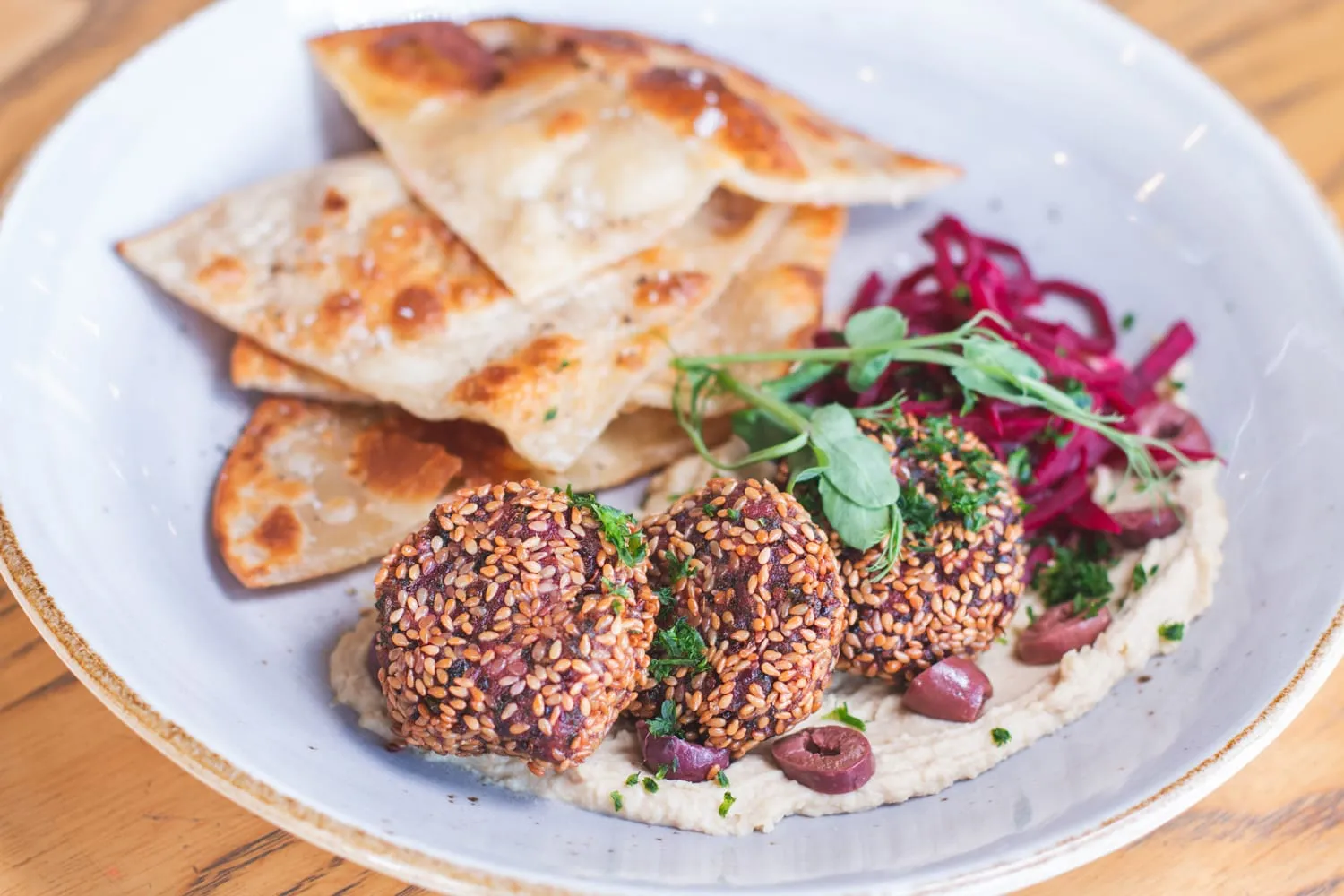 A plate with flatbread, pickled beetroot and fresh shoots