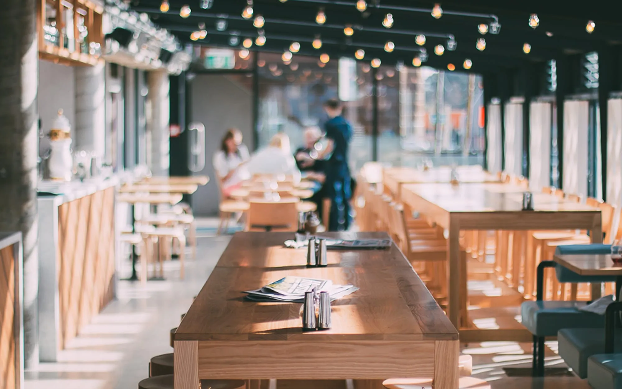 Sunlight across the long timber tables inside Monica’s Eatery